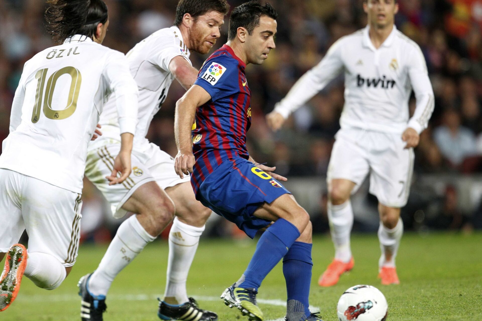 Xavi (Barça) face au Real Madrid de Xabi Alonso et Mesut Özil en 2012. Icon Sport